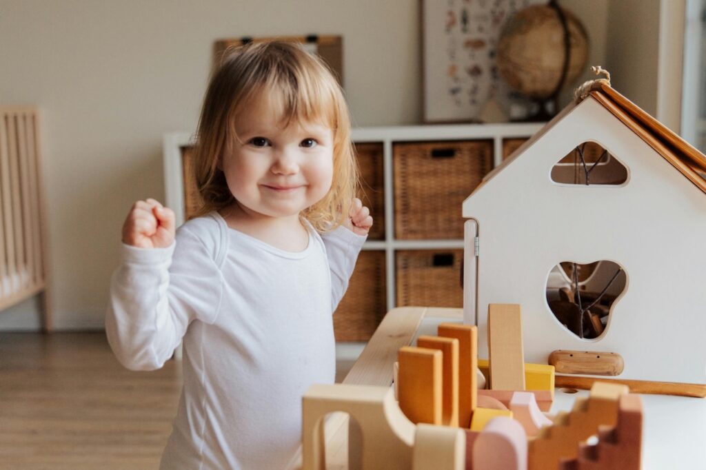 a child is pleased with her wood block display. 